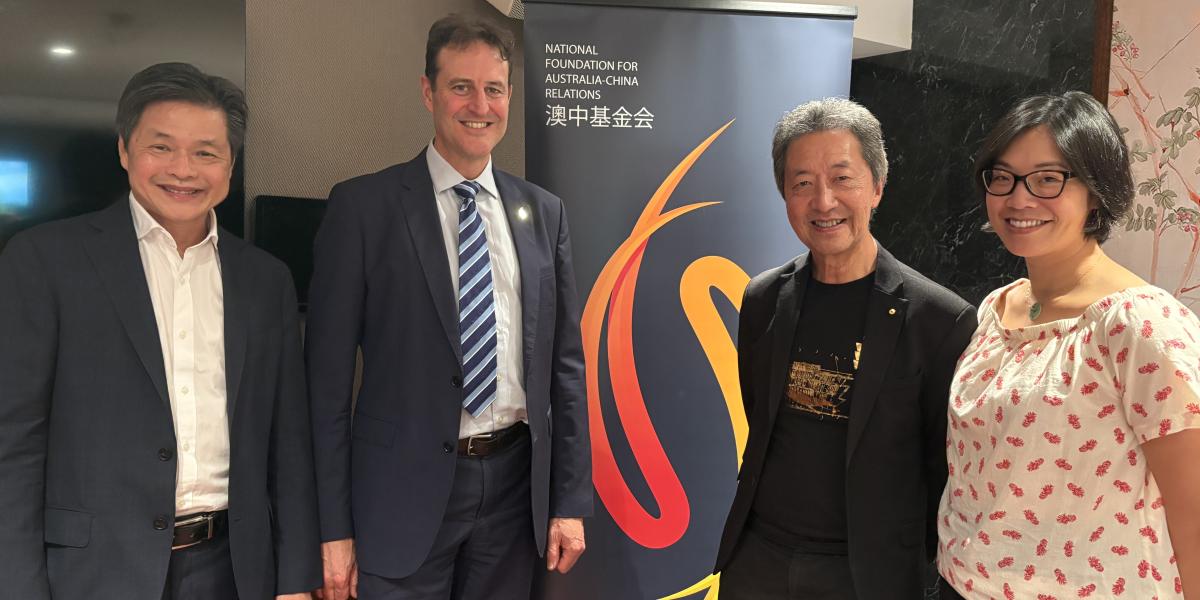 four people next to a banner 