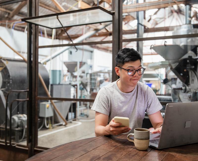 Individual working on a laptop in a factory setting