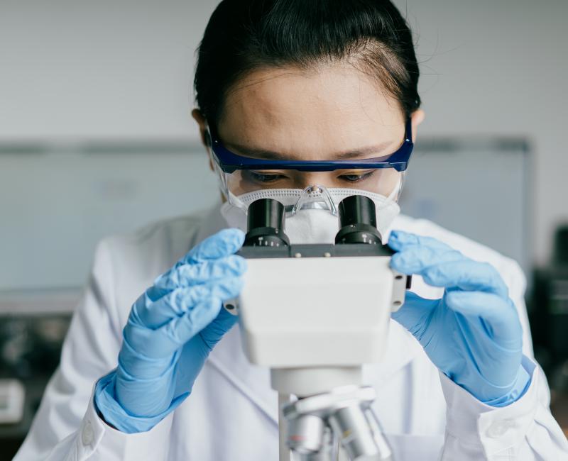 Scientific researcher looking into microscope
